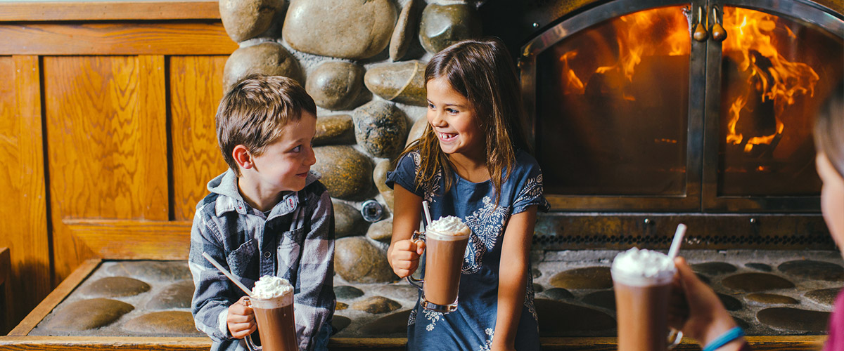 Children enjoying Hot Chocolate by the Fireplace