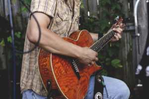 man playing a guitar outside